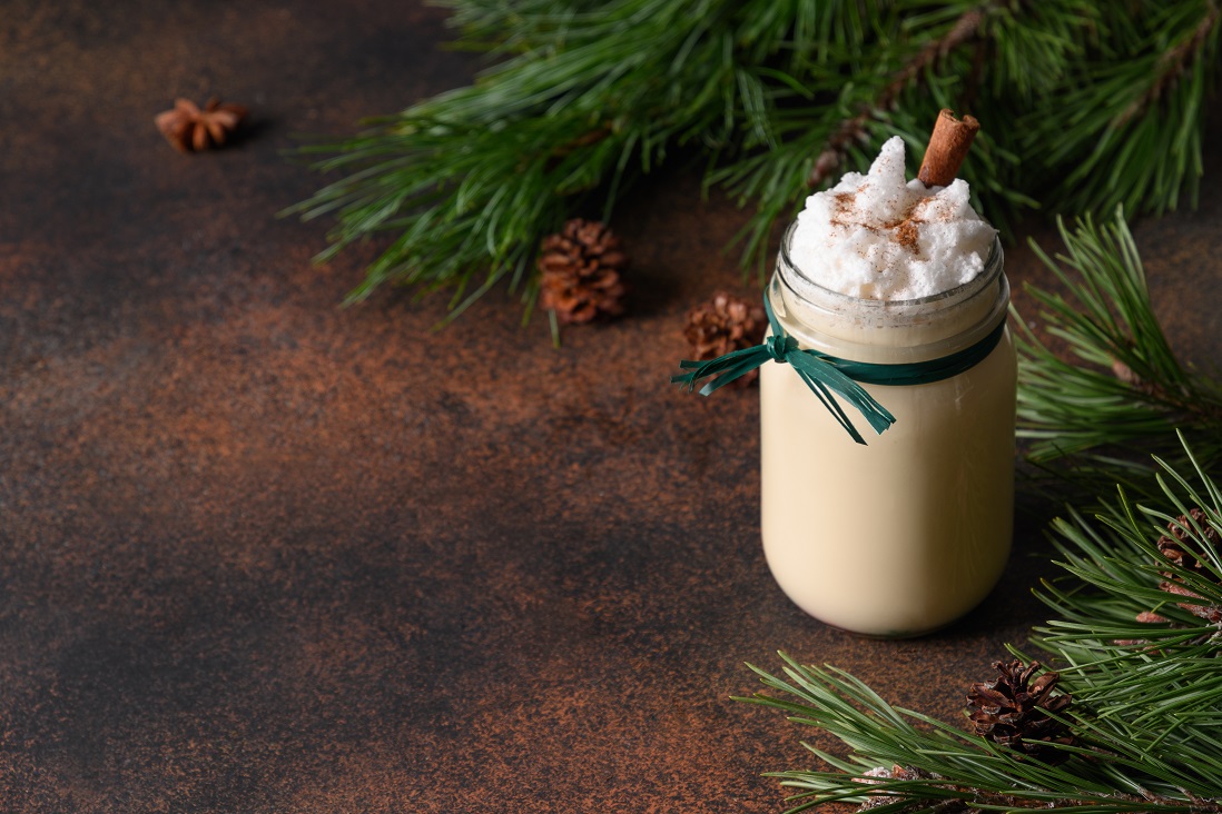 christmas-holiday-eggnog-mason-jar-with-cinnamon-decorated-fir-tree-brown-background.jpg