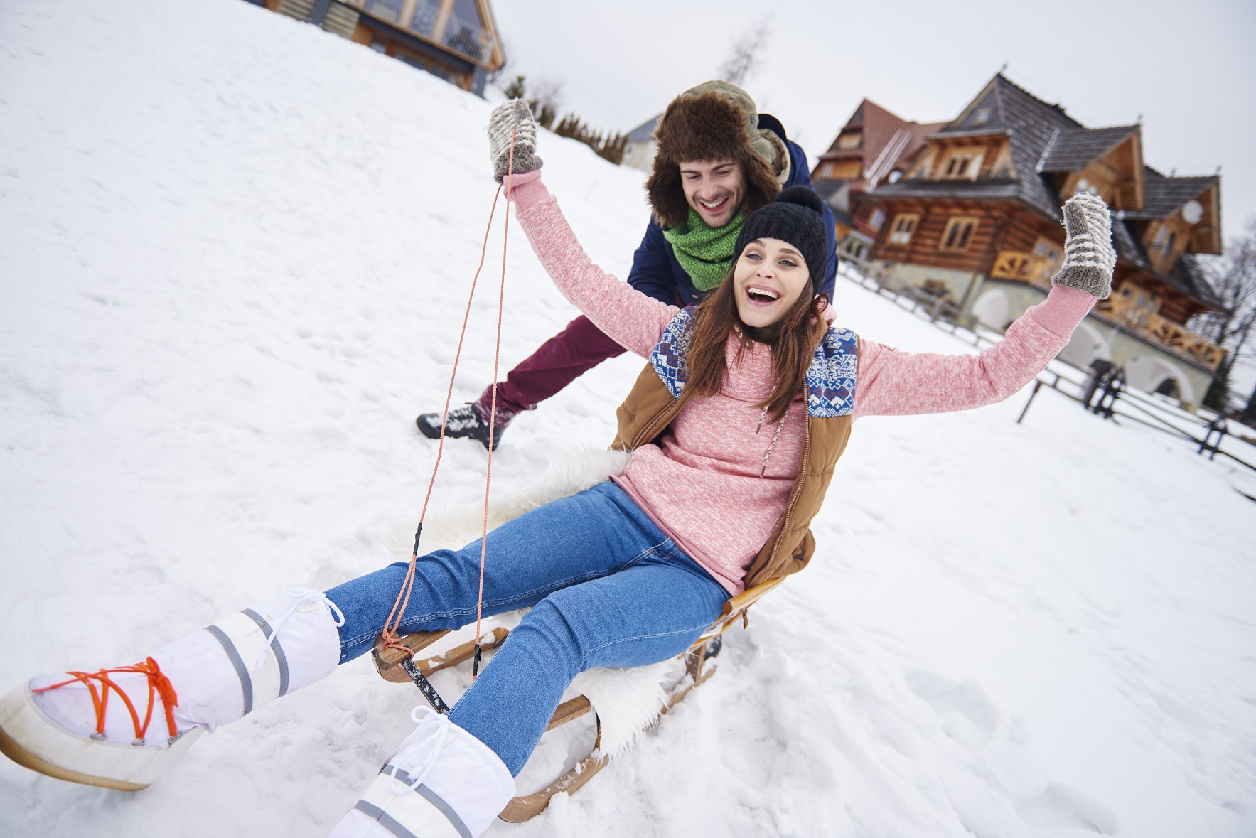 man-pushing-woman-down-hill-sled.jpg