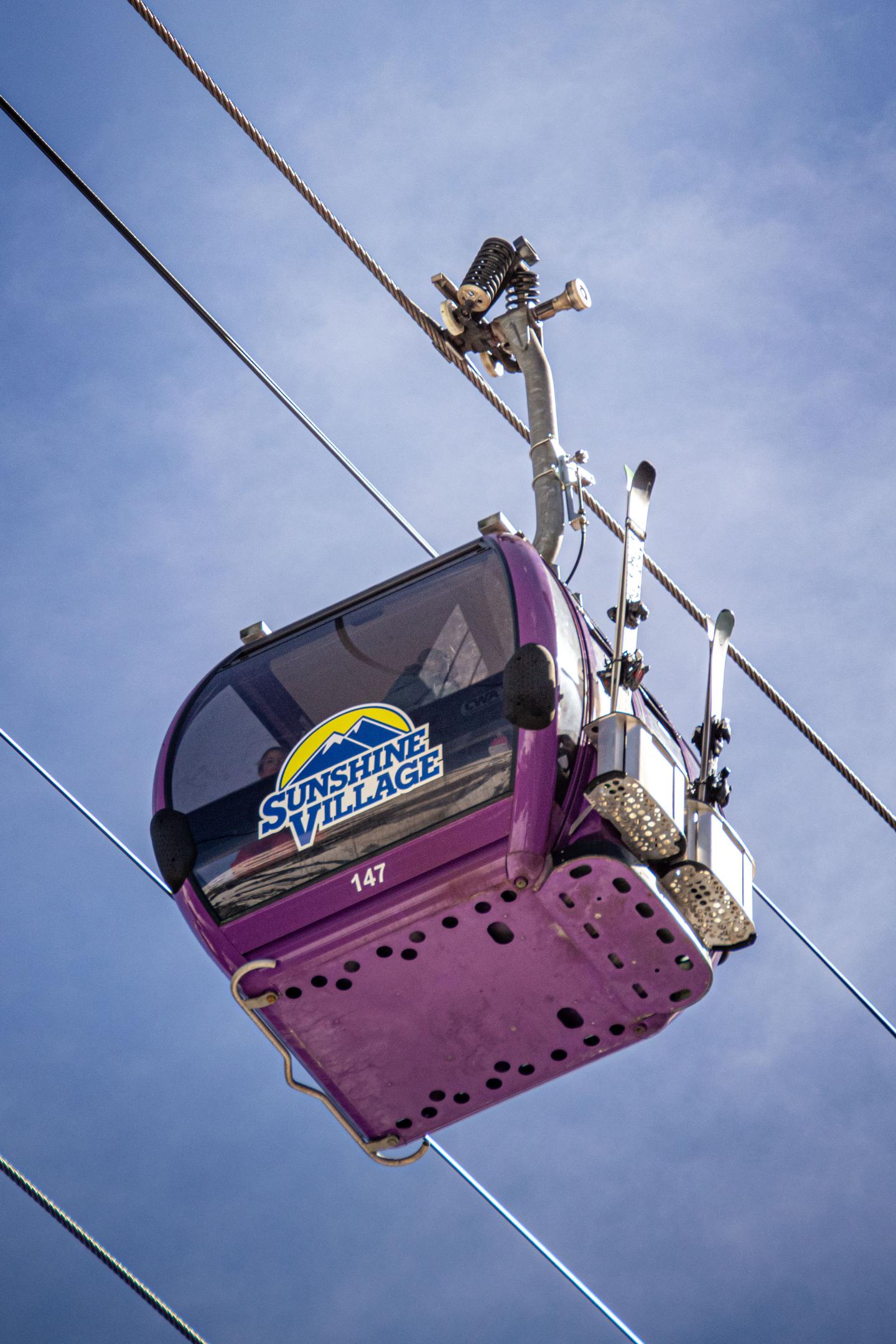 Purple cable car against a clear blue sky.