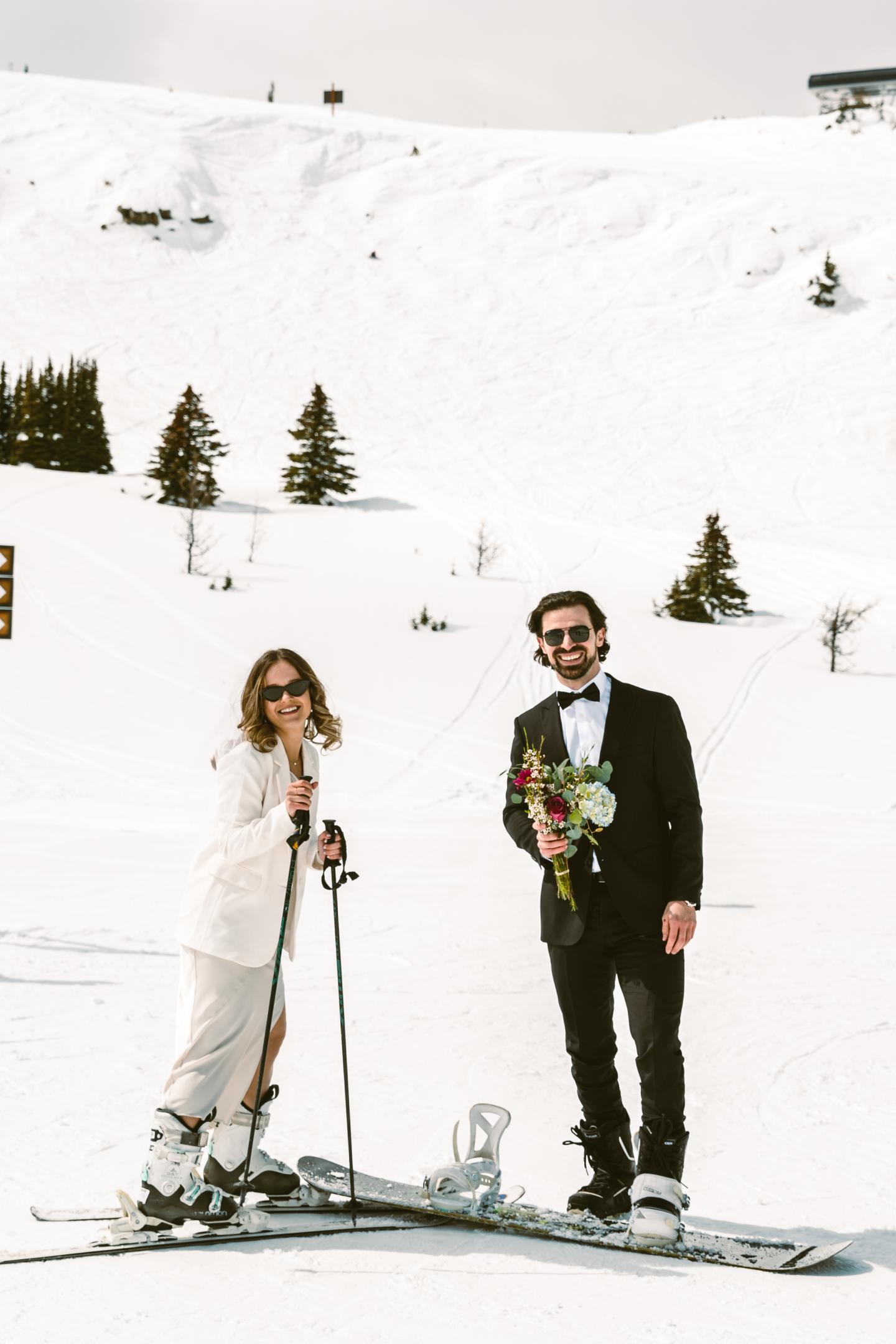 Couple in formal attire skiing on a snowy slope.