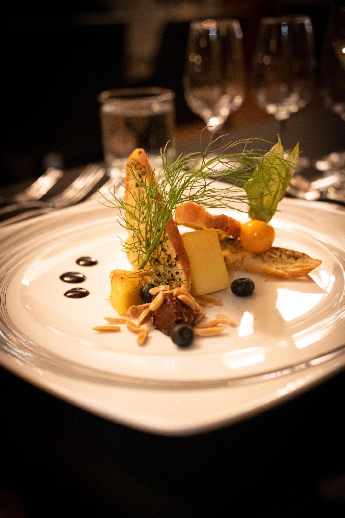 Elegant dessert plate with cheese, fruit, and garnish.