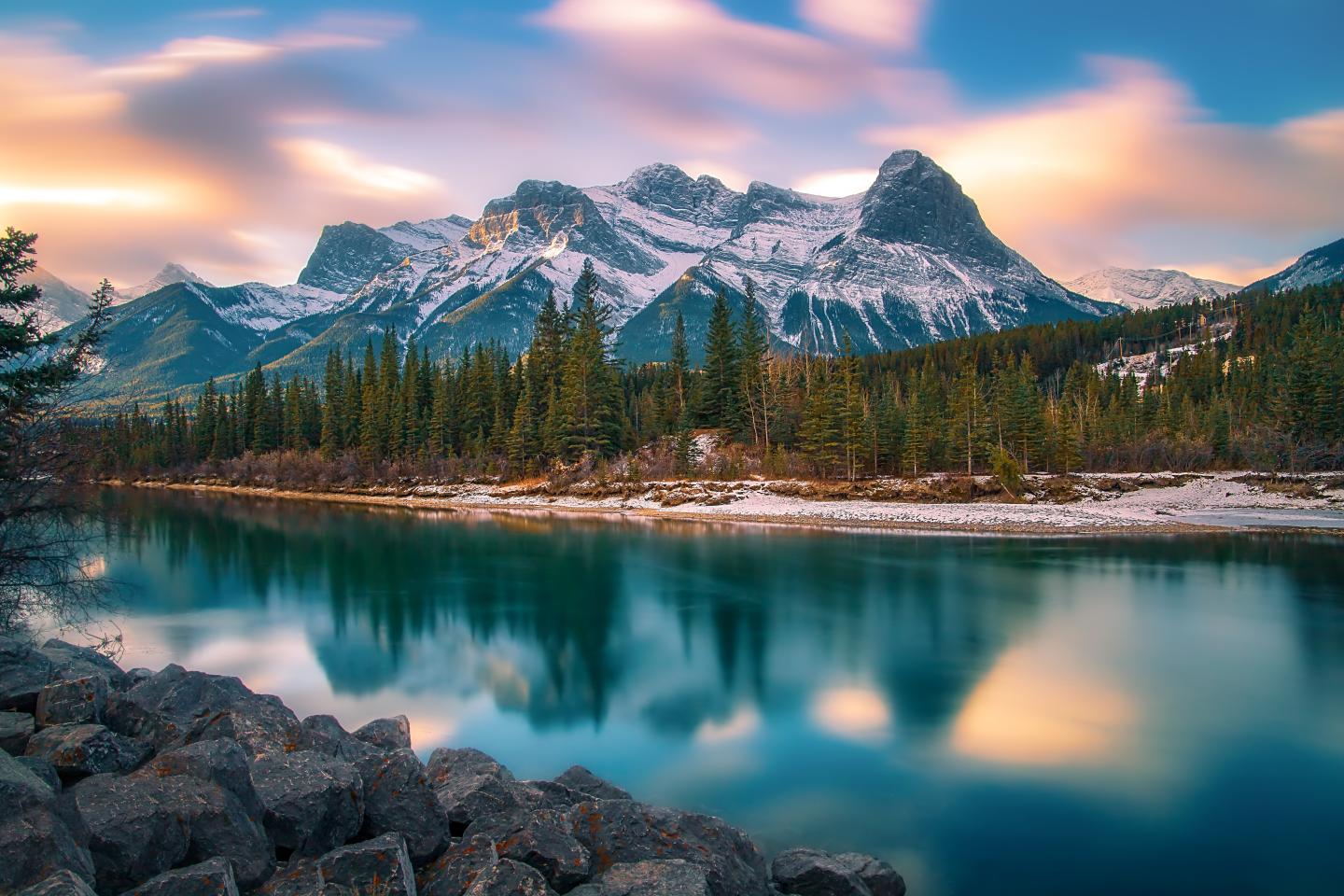 Majestic mountains reflected in a serene lake at sunrise.
