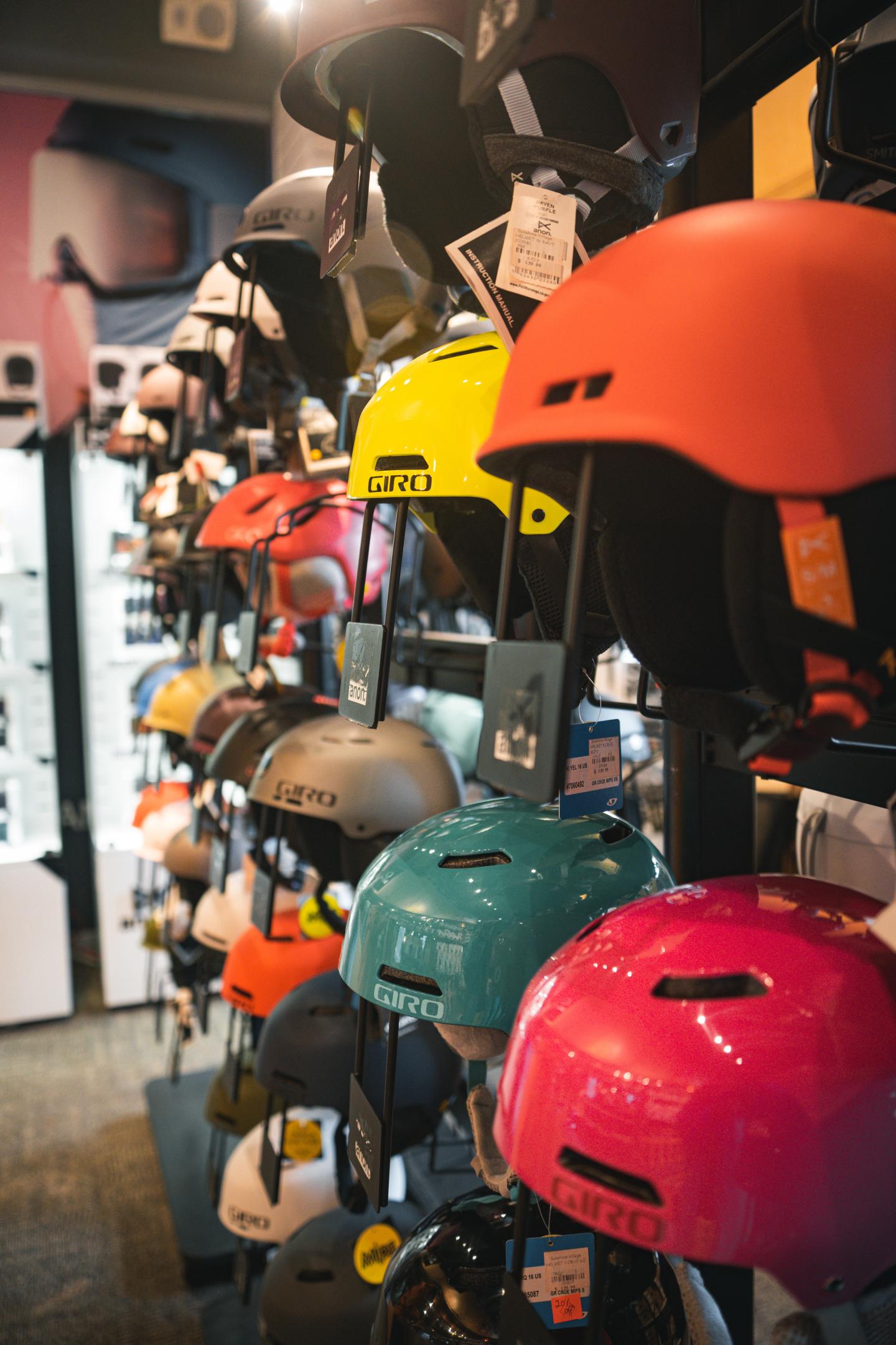 Colorful helmets displayed on store rack.