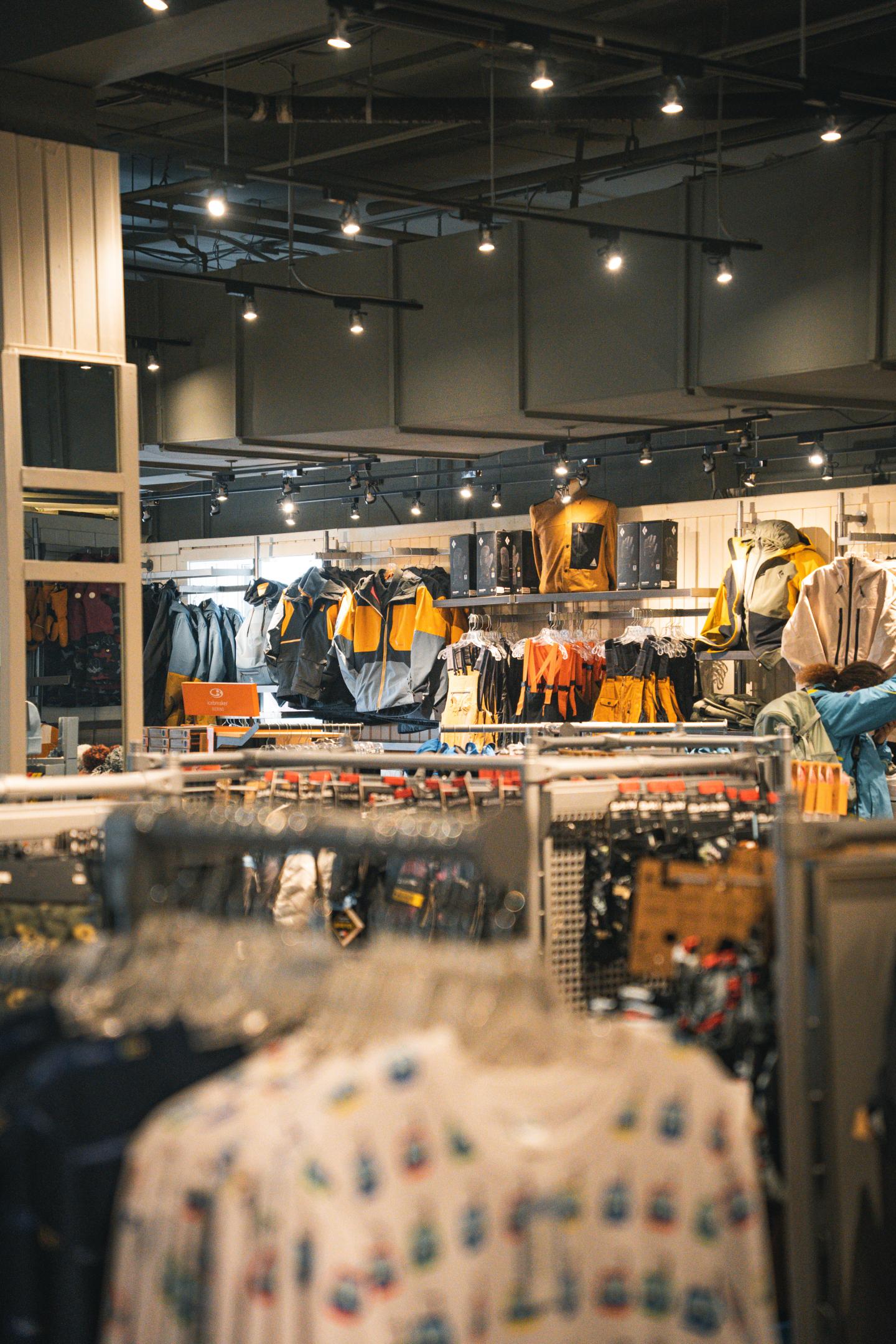 Clothing store interior with racks of colorful garments.