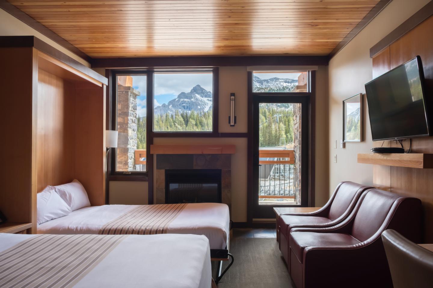 Hotel room with two beds, mountain view, and modern decor.