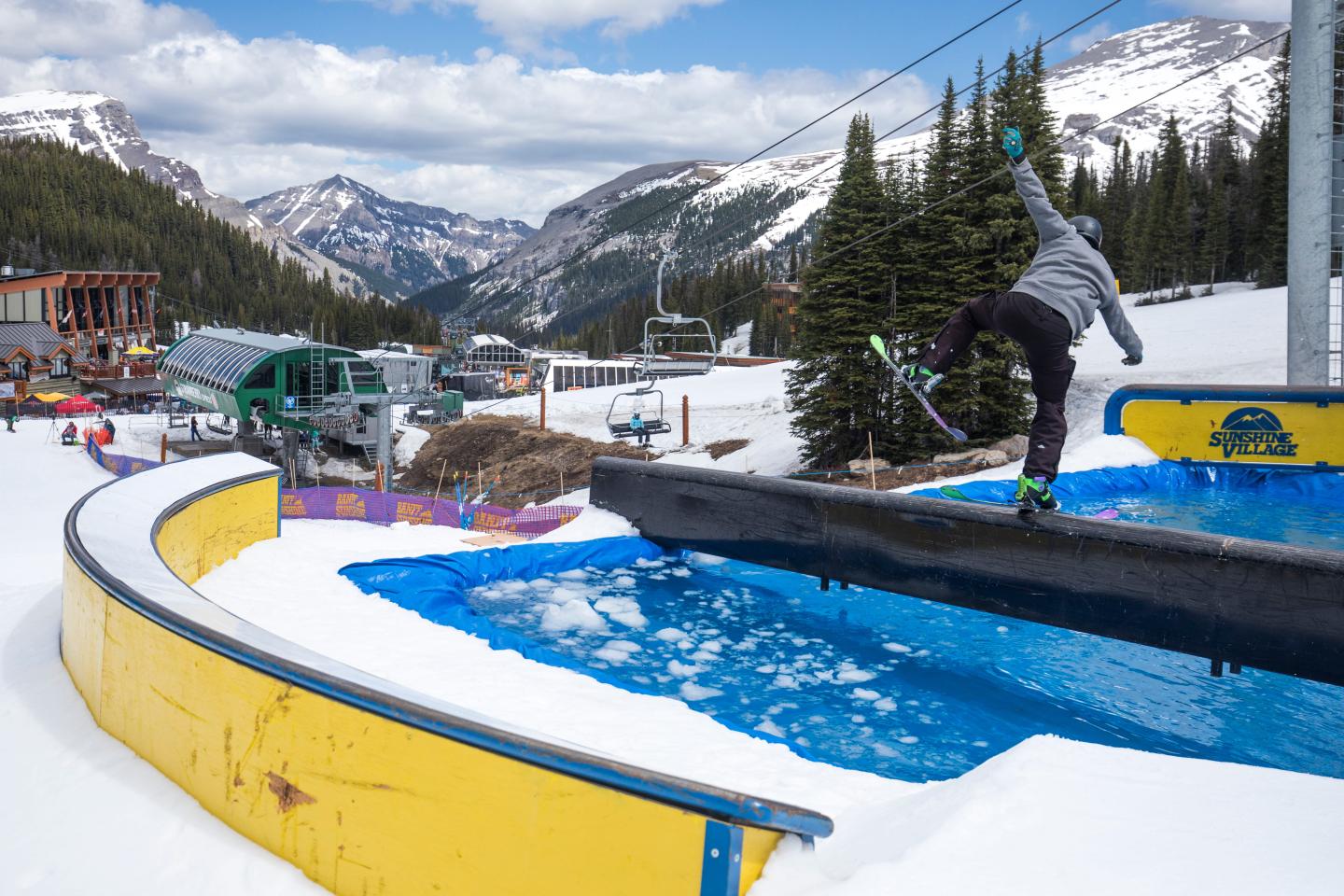 Snowy mountain resort with a bright blue outdoor pool and lounge chairs