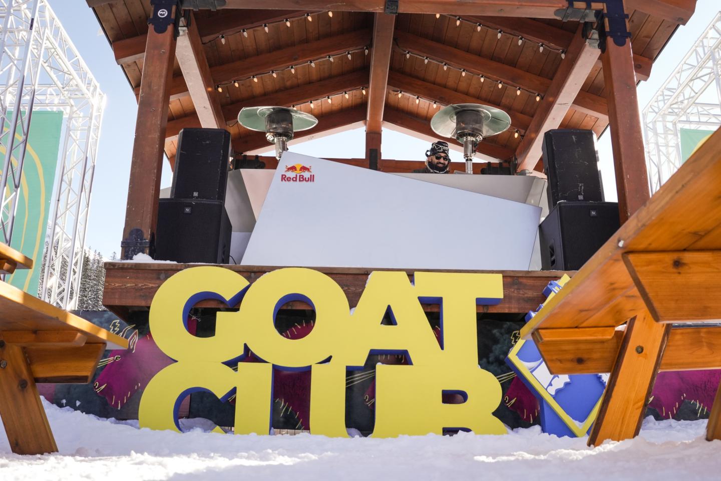 Snow-covered GOAT LAB sign beneath a wooden ski-lift structure.