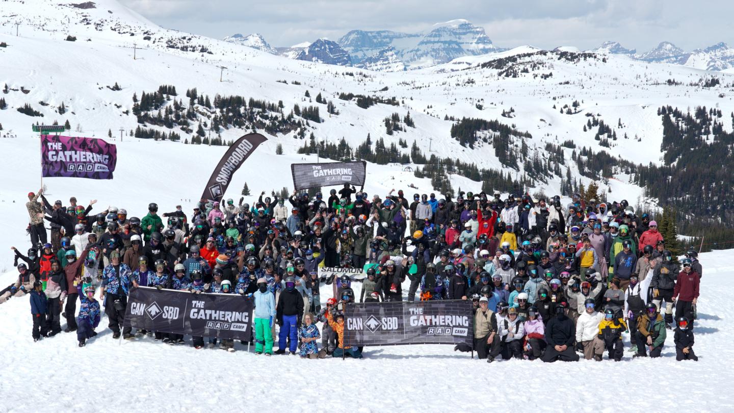 Large group of skiers and snowboarders gathered at a snowy mountain resort.