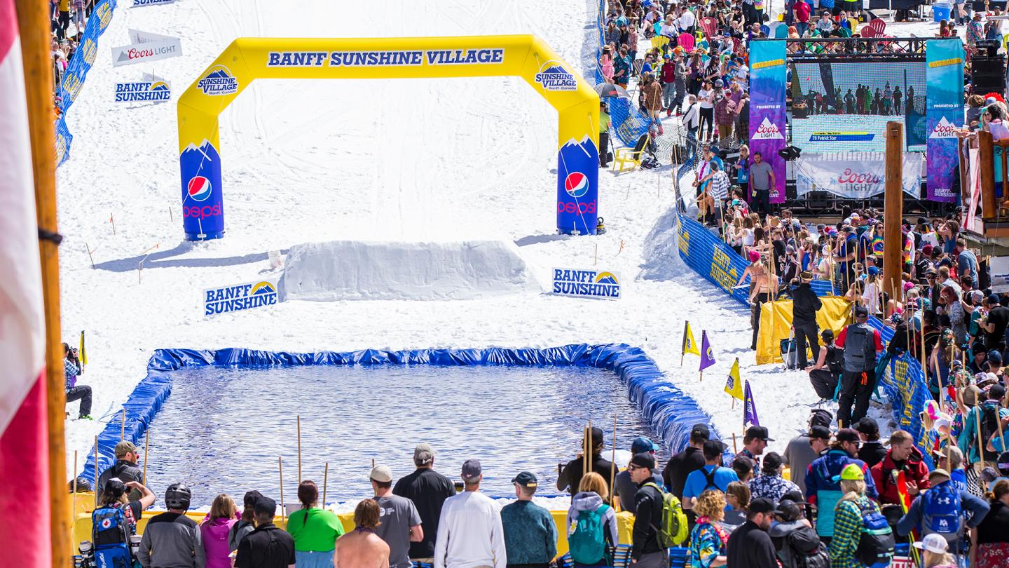 Runners cross the finish line at a crowded city road race.