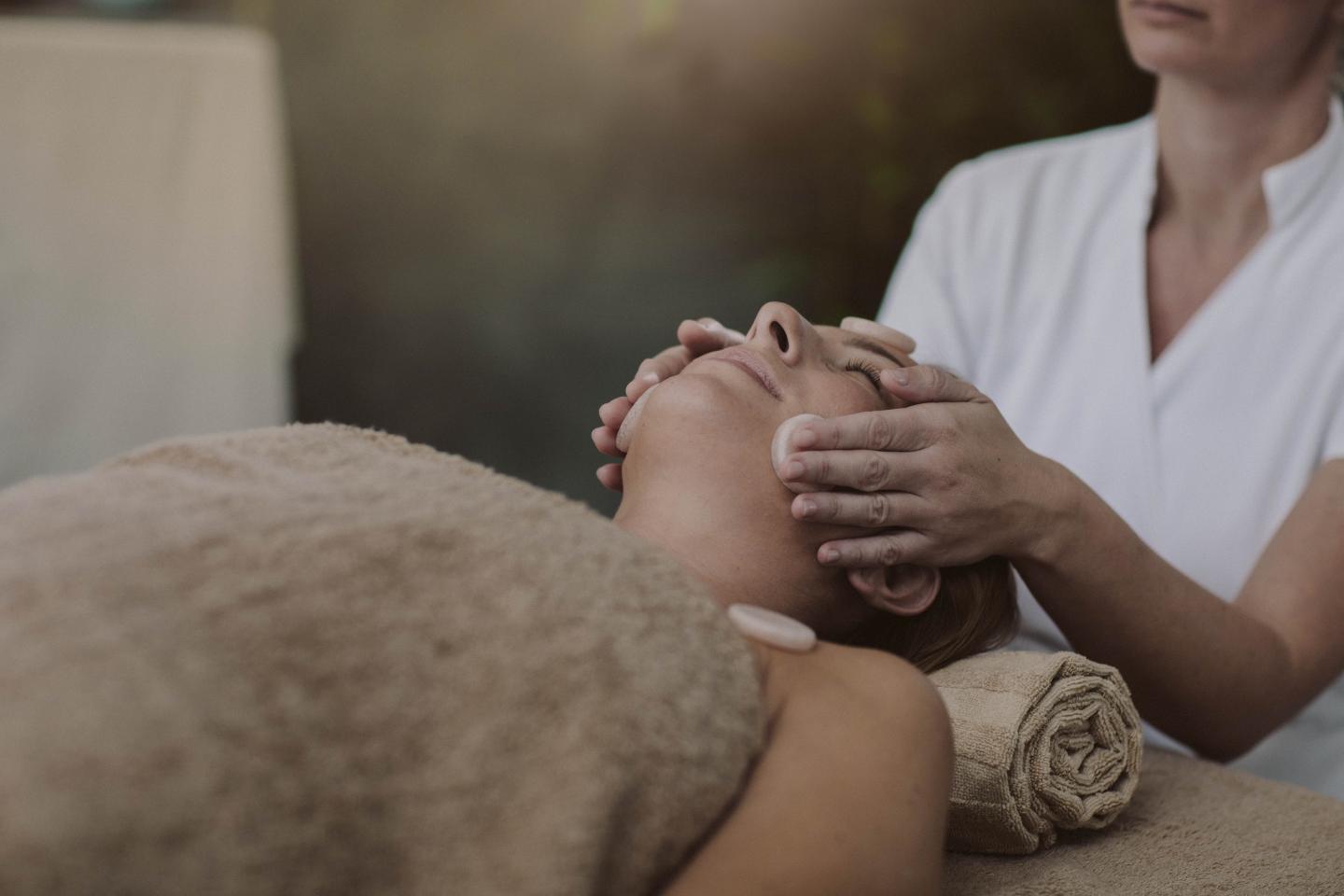 Woman receiving a facial massage at a spa.