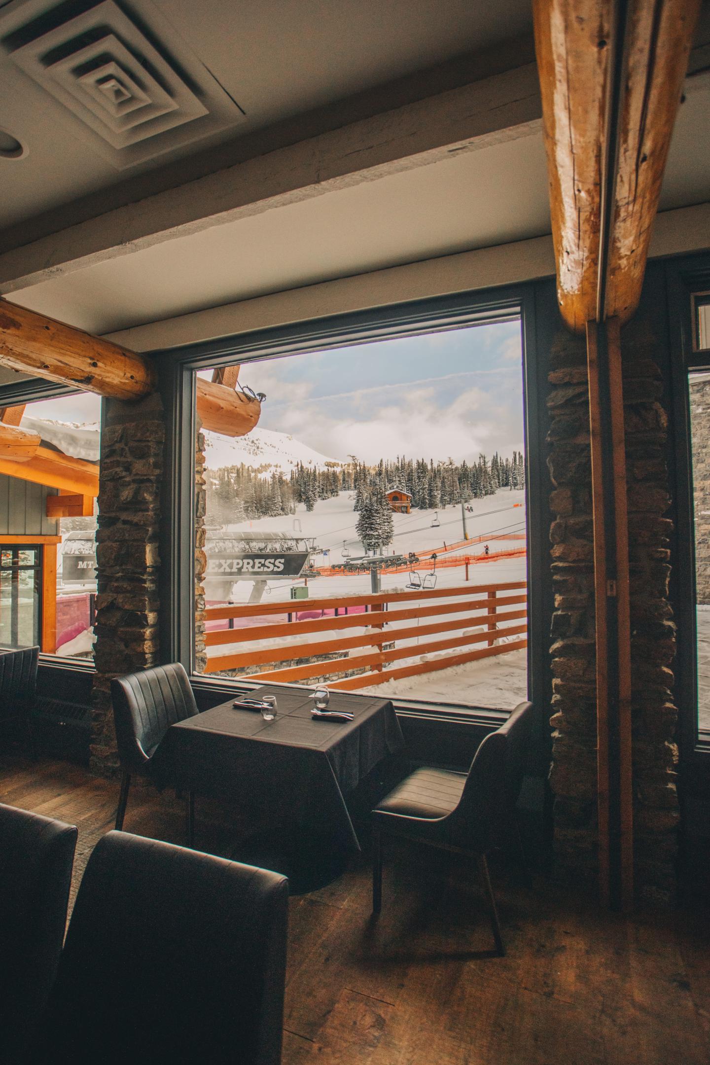 Cozy café interior with window seating overlooking a snowy street.